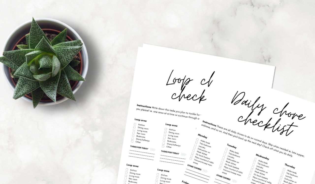 A picture of chore checklist printables on a table next to a plant.